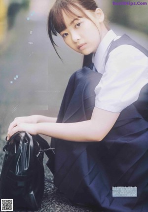 A woman in a school uniform is posing for a magazine.