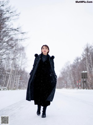 A woman wearing a black fur hat in the snow.