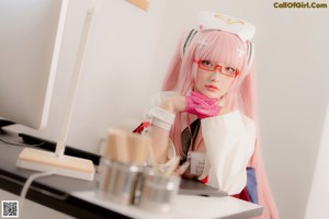 A woman in a nurse outfit sitting at a desk.