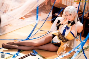 A woman in a yellow and black outfit sitting on the floor.