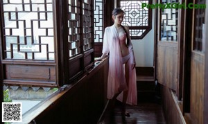 A woman in a pink lingerie sitting on a bench.