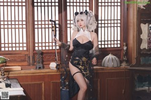 A woman sitting on top of a table holding a gun.