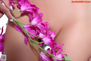 A naked woman sitting on top of a chair next to a plant.