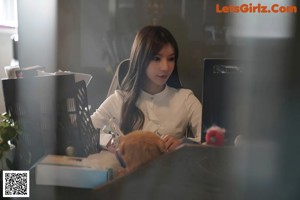 a woman sitting at a desk with her legs crossed