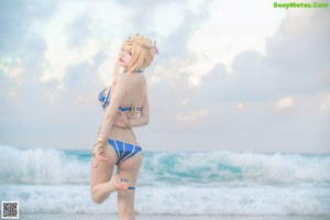 A woman in a bikini posing on the beach.