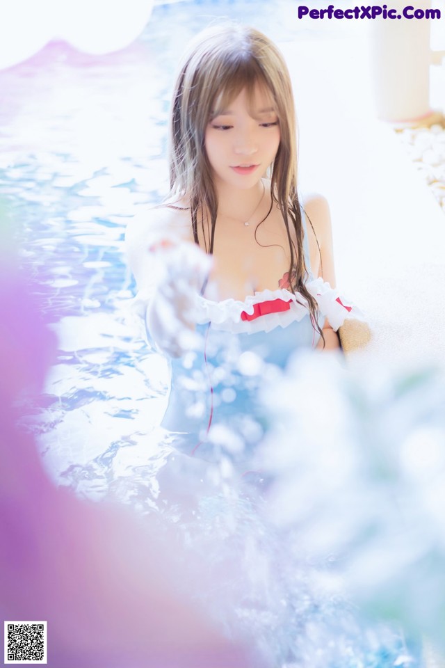 A woman in a blue and white dress in a pool.