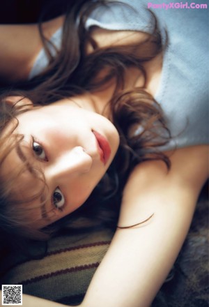 A woman sitting on top of a brown leather couch.