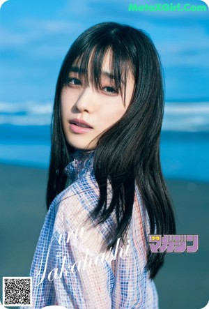 A woman with long black hair is looking up at the sky.