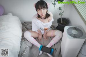 A woman in a white shirt holding a toothbrush in her mouth.