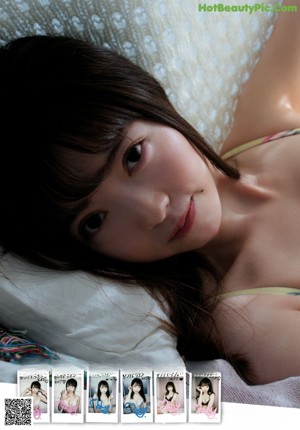 A woman with long brown hair sitting on a bed.