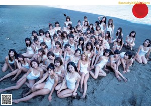 A group of women in white bathing suits standing on a beach.