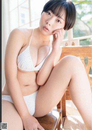 A woman in a pink and white striped bikini posing for a picture.