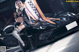 A woman in a bikini sitting on top of a car.