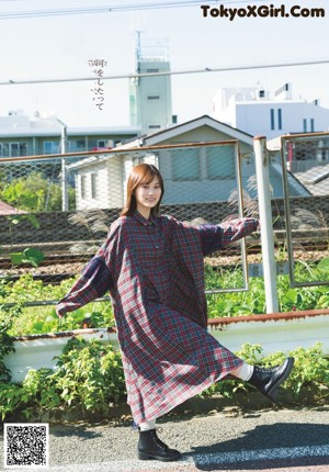 A woman in a white top and black shorts posing for a magazine.