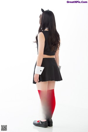 A woman dressed in a maid outfit posing for a picture.