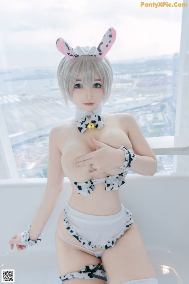 A woman in a bunny costume sitting in a bathtub.