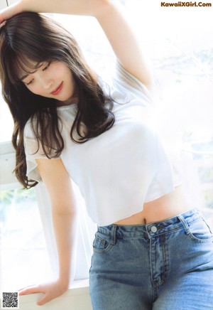 A woman in a white dress is posing for a magazine.