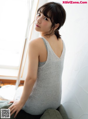 A young woman sitting on the floor next to a table.