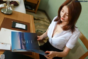 A woman sitting in a chair with her legs crossed.