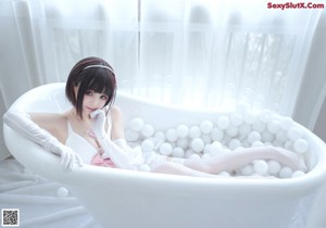 A woman in a pink lingerie sitting on a chair.
